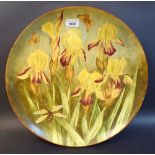 An Art Pottery circular charger, printed and painted with yellow irises, moths and dragonfly,