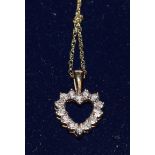 A diamond heart pendant, open heart pendant inset with fourteen round cut diamond accents,