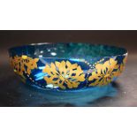 An Art Nouveau blue glass circular bowl, applied in gilt with honeysuckle flowerheads, 24.