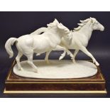 A Royal Worcester model galloping ponies, glazed in white, printed mark in gold,