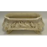 A reproduction alabaster-type indoor planter, decorated with putti,