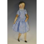 An early 19th century child's softwood doll, jointed body, painted features, later Gingham dress,