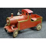 A 1950's pedal car, as a train, painted red and green plywood body, tin wheels.