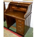 An early 20th century oak roll top desk,