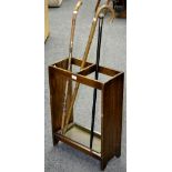 A 1940's oak stick stand; a silver ferruled walking cane; two walking sticks.
