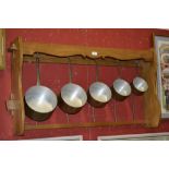 A French oak kitchen rack and five graduated saucepans