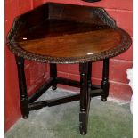 An unusual early 20th century carved oak corner drop leaf table