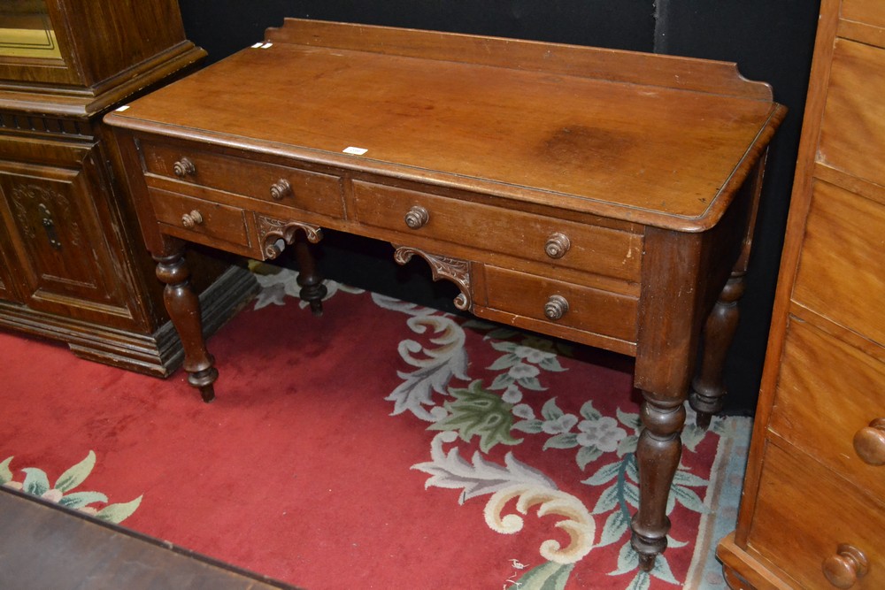 A Victorian mahogany desk, quarter back, oversailing top above an arrangement of drawers,