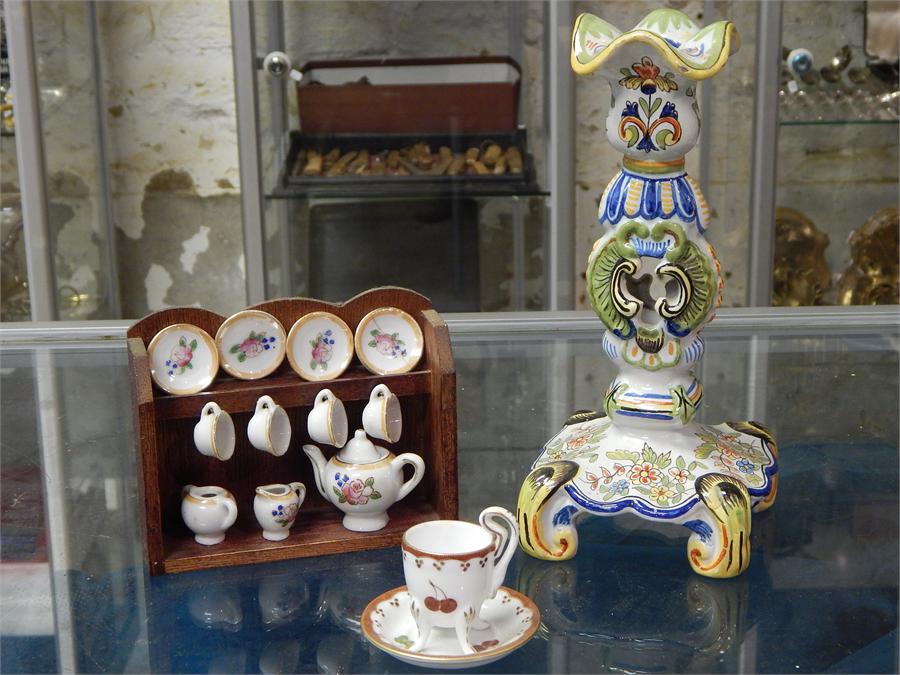 A selection of three items, including a decorative delft candlestick, an ornamental cup and saucer