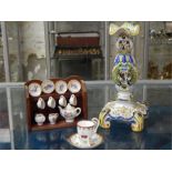 A selection of three items, including a decorative delft candlestick, an ornamental cup and saucer