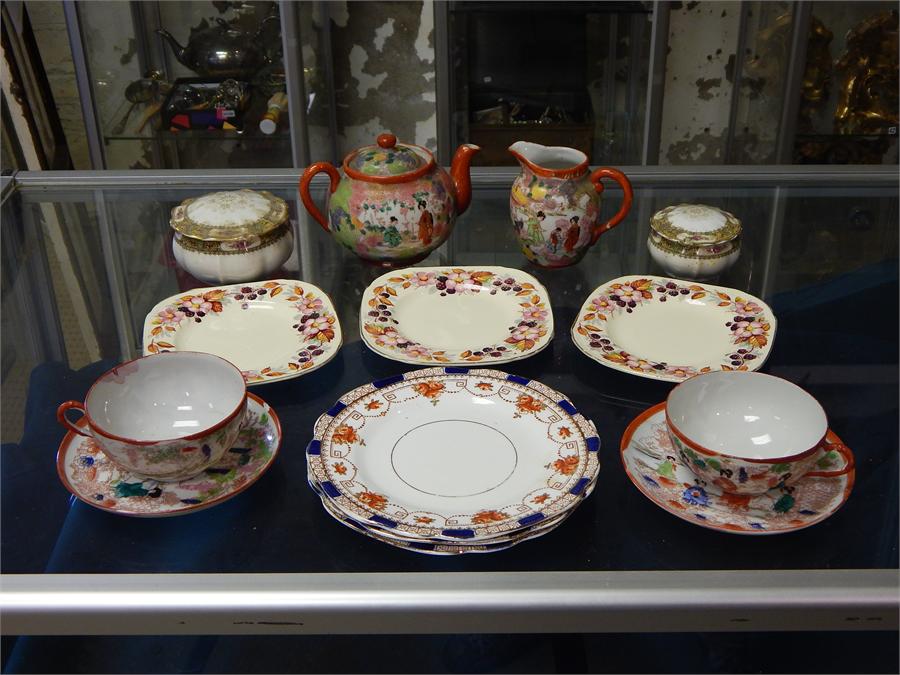A collection of decorative tea set items including Japanese tea pot, milk jug and cup and saucer.