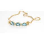 14ct yellow gold & blue topaz bracelet weight: approx 3.8 grams