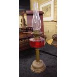 Antique oil lamp with dual burner & red glass font, 66cm high approx.