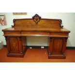 Victorian mahogany pedestal sideboard with scroll carved back above inverted breakfront top, 3