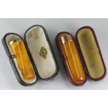 Two 9ct gold & amber cigar holders both in original cases