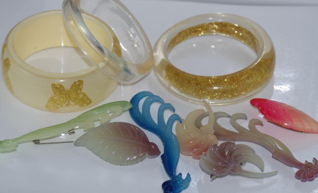 Various lucite 1950s brooches with 3 early plastic bangles
