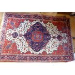 A Sarouk multi coloured rug with allover repeating foliate design with large central lozenge