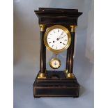 A Portico clock, in ebonised wood, columns with brass bases and capitals, enamel dial & pendulum