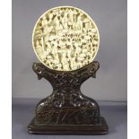A C19th Chinese carved ivory roundel on black laquered stand D6.3cm base H7cm W8cm D3.5cm