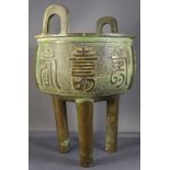 A Chinese C19th Qing Dynasty bronze archaic tripod censer with twin handles above lipped rim and