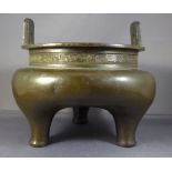 A Chinese Ming Dynasty bronze tripod bulbous censer with twin handles above lipped rim with