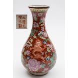 A Chinese porcelain vase: of pear shaped form decorated with dragons amongst peony and other blooms