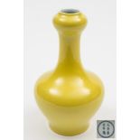 A Chinese yellow glazed garlic-necked bottle vase: the exterior covered with a bright yellow glaze,