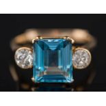 A gold, aquamarine and diamond three-stone ring: with central rectangular aquamarine,