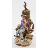 A Meissen figure of a rat catcher: the smiling youth holding a rat above a basket at his side,