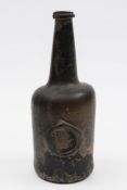 A sealed mallet shaped wine bottle: of medium olive colour with cylinder body and raised tapering
