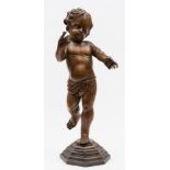 A 19th century Continental carved wooden figure of a Putto: wearing a loin cloth and mounted on a