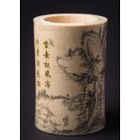 A Japanese carved ivory brush pot: decorated overall with figures in a mountainous landscape,