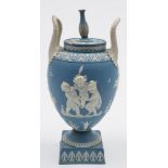 A Wedgwood pale blue jasper ware two-handled urn and cover: decorated in high relief with