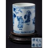 A Chinese blue and white cylindrical brushpot: painted with three figures and a deer in a