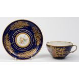 A later decorated Sèvres cup and saucer: the ogee cup finely painted with a courting couple in a