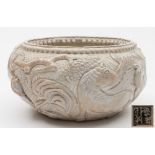 An unusual Chinese cream glazed stoneware bowl: decorated in relief with two horses amongst