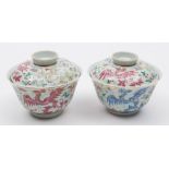 A pair of Chinese famille rose 'phoenix' bowls and one cover: each painted with three phoenix in