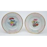 A pair of Wallendorf porcelain plates: of circular form with pierced rims picked out in pink and