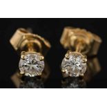 A pair of diamond single stone ear studs: each with a circular,