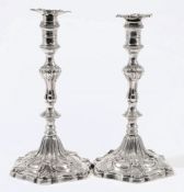 A pair of George III silver cast candlesticks, maker William Cafe, London, 1760: crested,