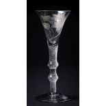 An air twist wine glass: the trumpet shaped bowl engraved with a single bloom and butterfly set on