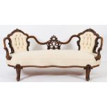 A Victorian carved walnut twin chair back settee:,