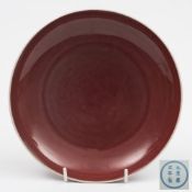A Chinese copper-red glazed saucer dish: with rounded sides and short foot rim,