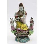 An unusual Chinese famille rose figure of Guanyin: wearing flowing robes and an elaborate necklace,