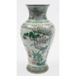 A Chinese famille verte baluster vase: finely painted on a floral moulded ground with a continuous