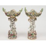 A pair of Meissen table centrepieces: each modelled with a pair of scantily clad cherubs supporting