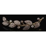 A yellow metal and diamond mounted leaf design spray brooch: pave-set with circular,