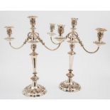 A pair of 19th century plated twin-branch candelabra: with foliate decorated urn-shaped nozzles and