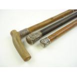 Two Indian white metal mounted walking canes and a silver mounted horn handled walking cane:.