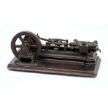 A 19th century single piston horizontal steam engine:, the 7 inch iron flywheel with brass crank,